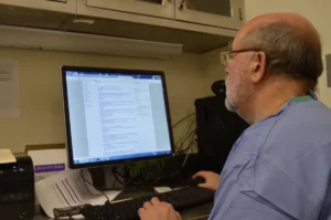 White Mountain Forensic Dr. Andrew researching autopsy info on a computer